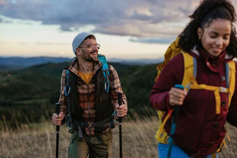 Two hikers enjoying a scenic trek in nature during sunset