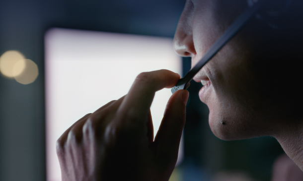 A person using a headset while engaged in a conversation at a workstation