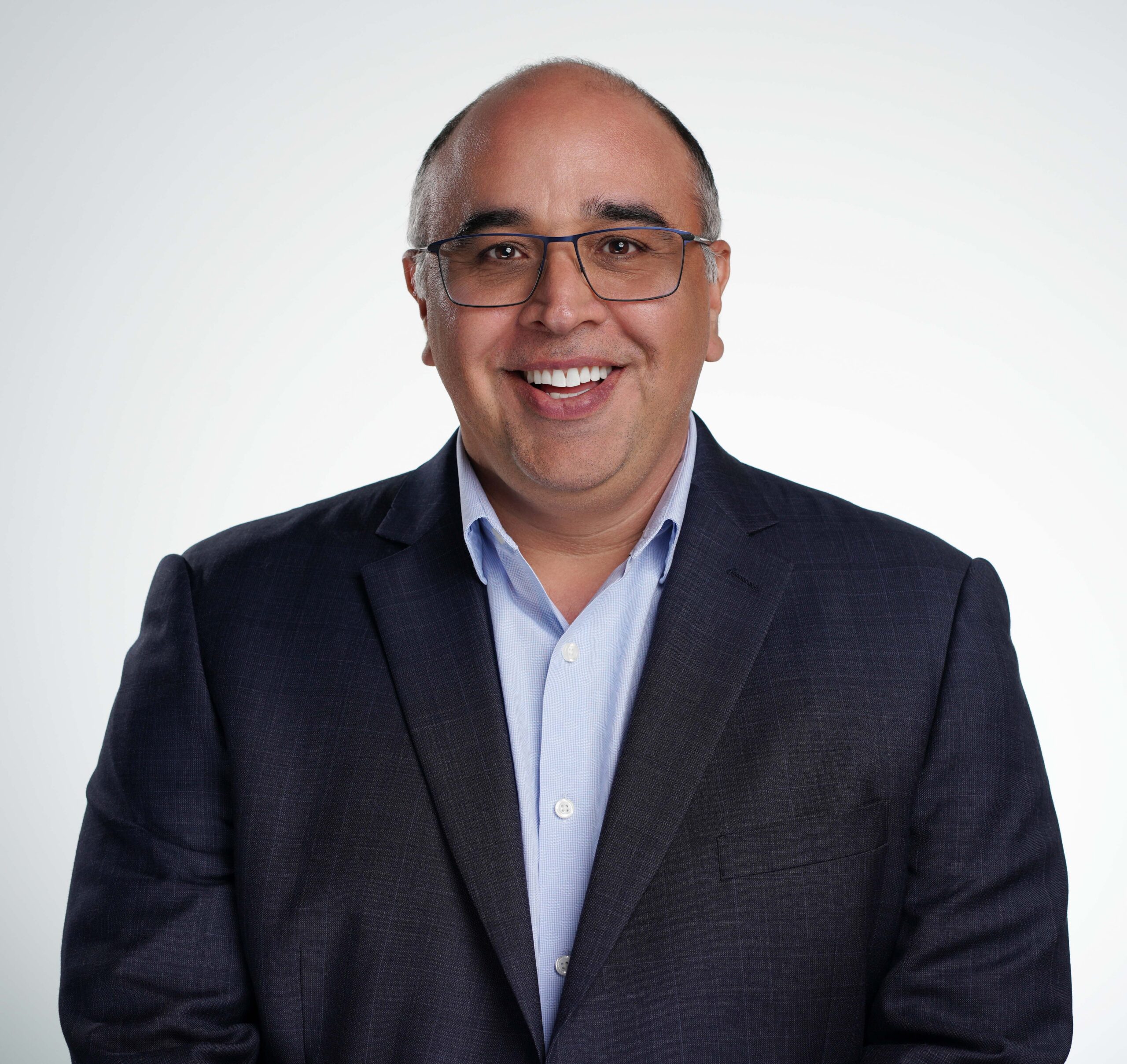 A professional smiling man in a suit, representing a positive and approachable business demeanor