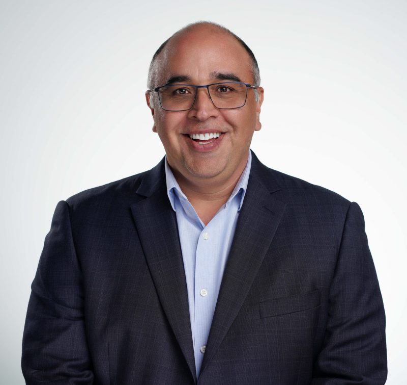 A professional smiling man in a suit, representing a positive and approachable business demeanor