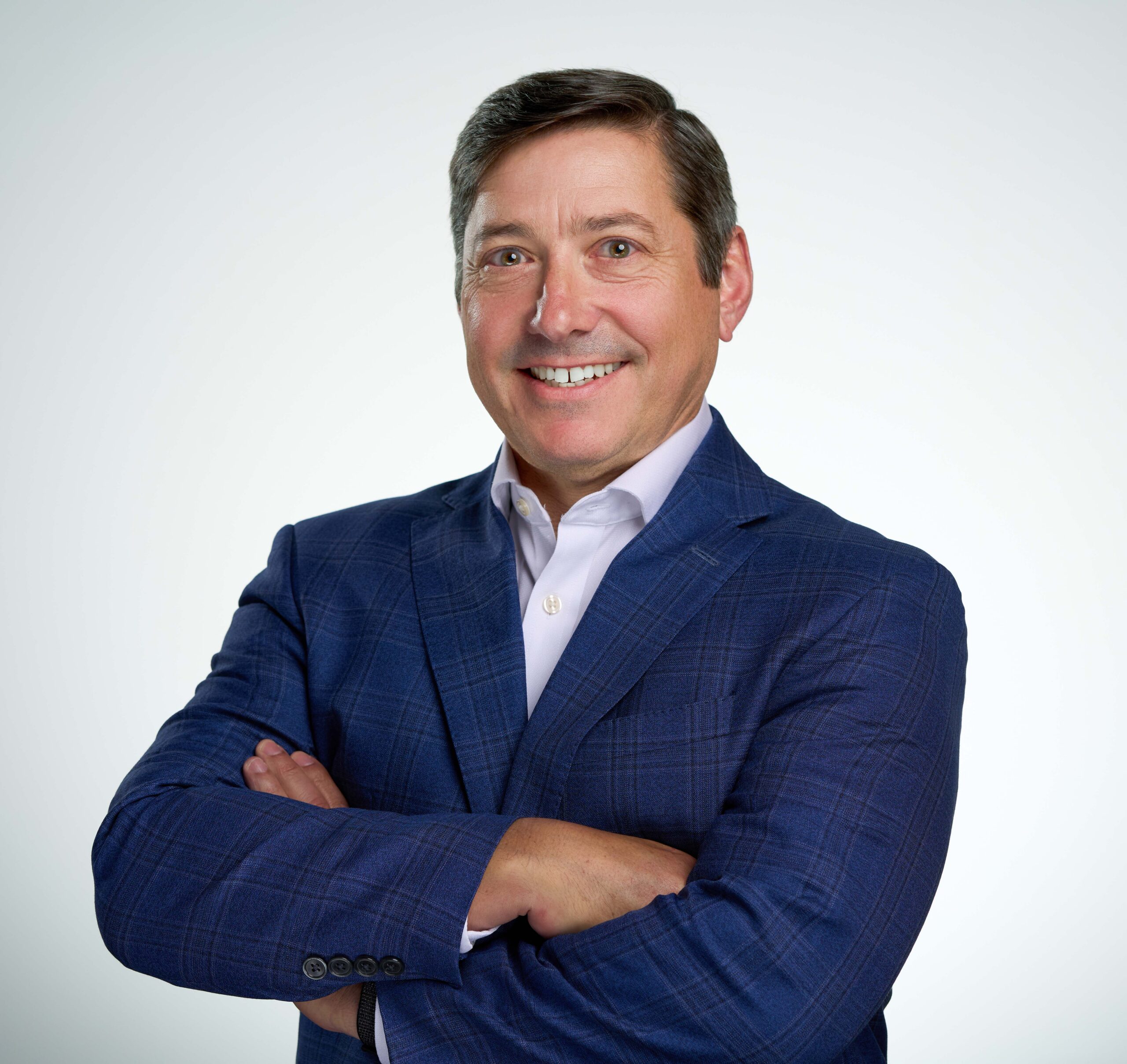 Professional portrait of a smiling man in a blue blazer, conveying confidence and approachability