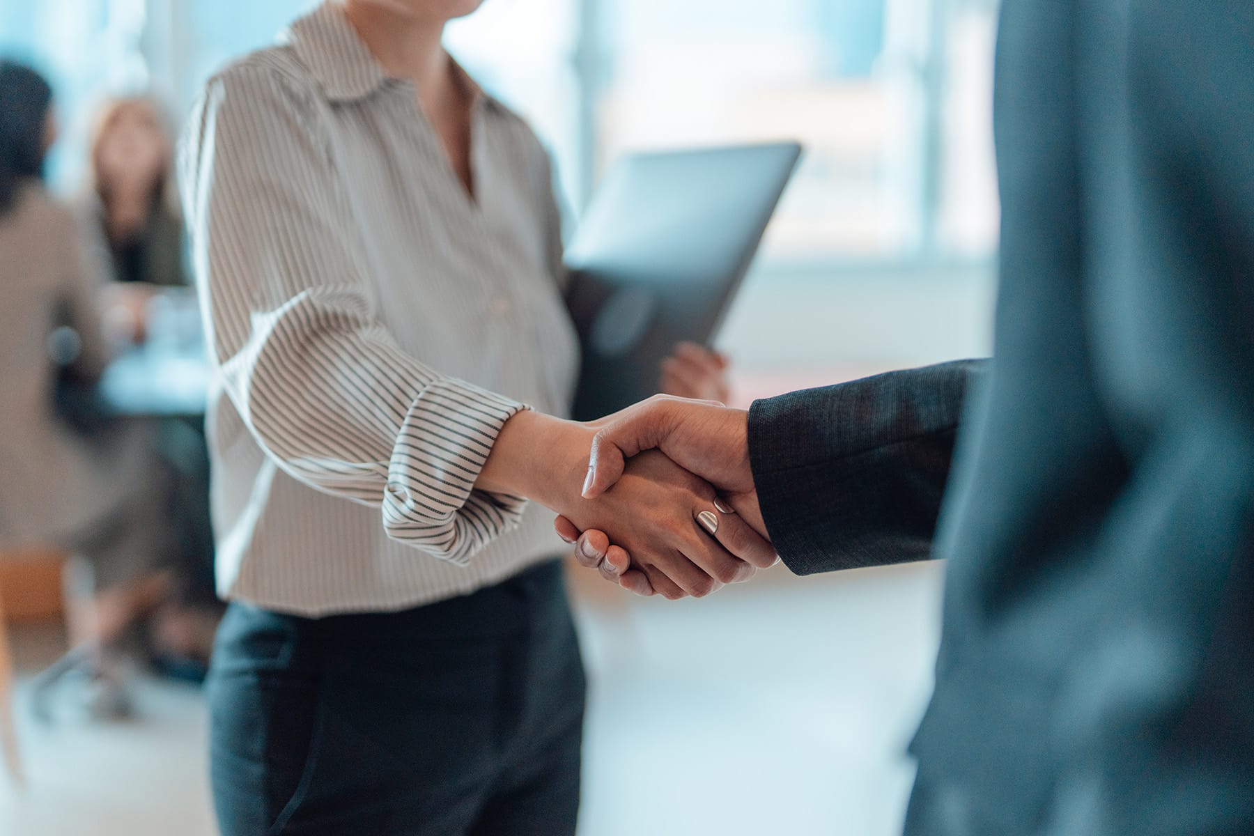 Two professionals shaking hands to signify a new partnership or agreement